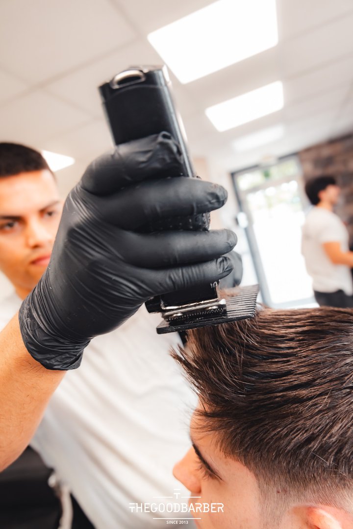 Corte de pelo con máquina eléctrica en primer plano en The Good Barber